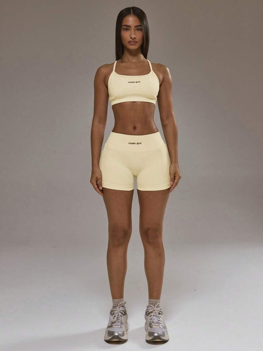 Conjunto de sujetador deportivo con espalda cruzada y short amarillo