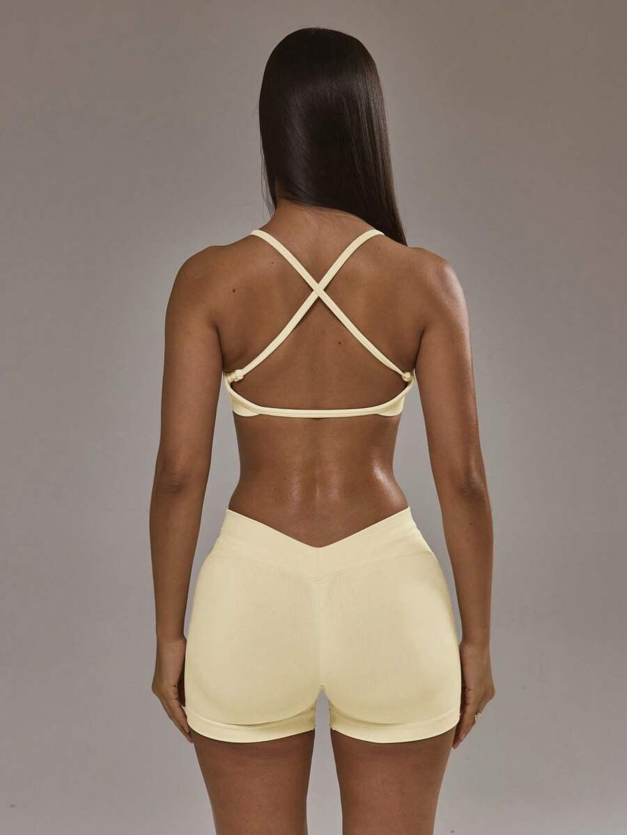 Conjunto de sujetador deportivo con espalda cruzada y short amarillo