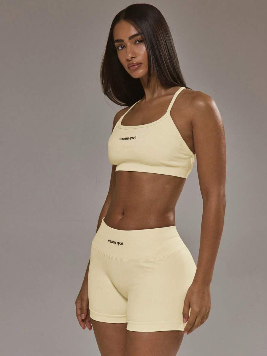 Conjunto de sujetador deportivo con espalda cruzada y short amarillo