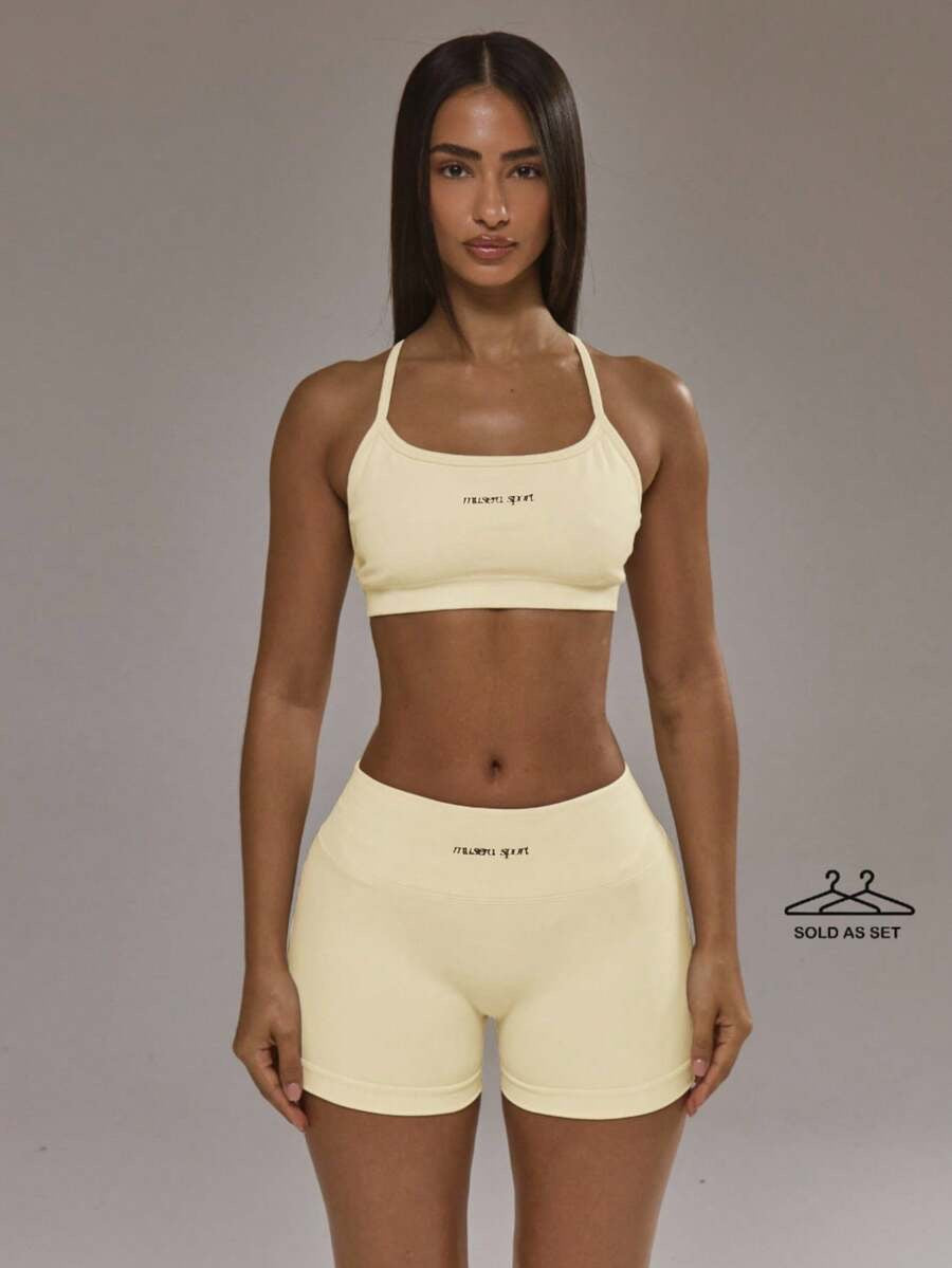 Conjunto de sujetador deportivo con espalda cruzada y short amarillo